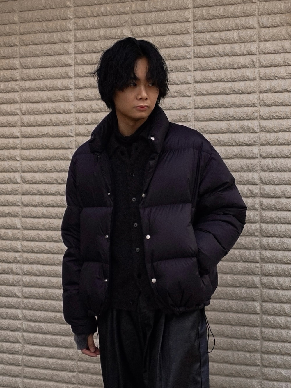 ブラック系のスラックス、ブラック系のカーディガン/ボレロ、ブラック系のスニーカーを着用したメンズの冬コーディネートの2枚目の写真