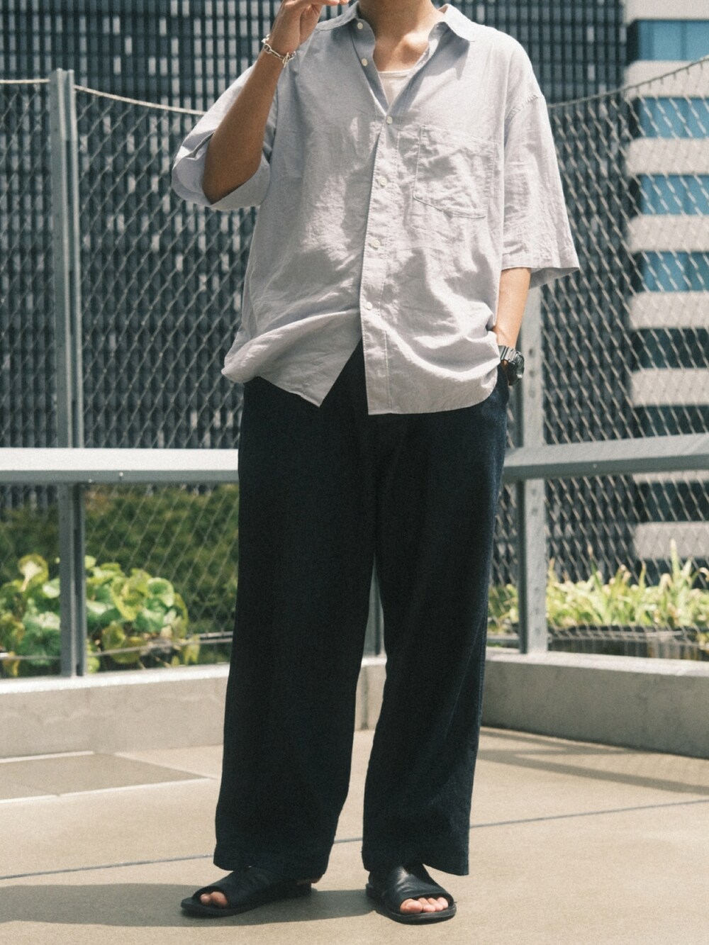 ブルー系のデニムパンツ、ブラック系のサンダル、ブルー系のシャツ/ブラウスを着用したメンズの夏コーディネートの3枚目の写真