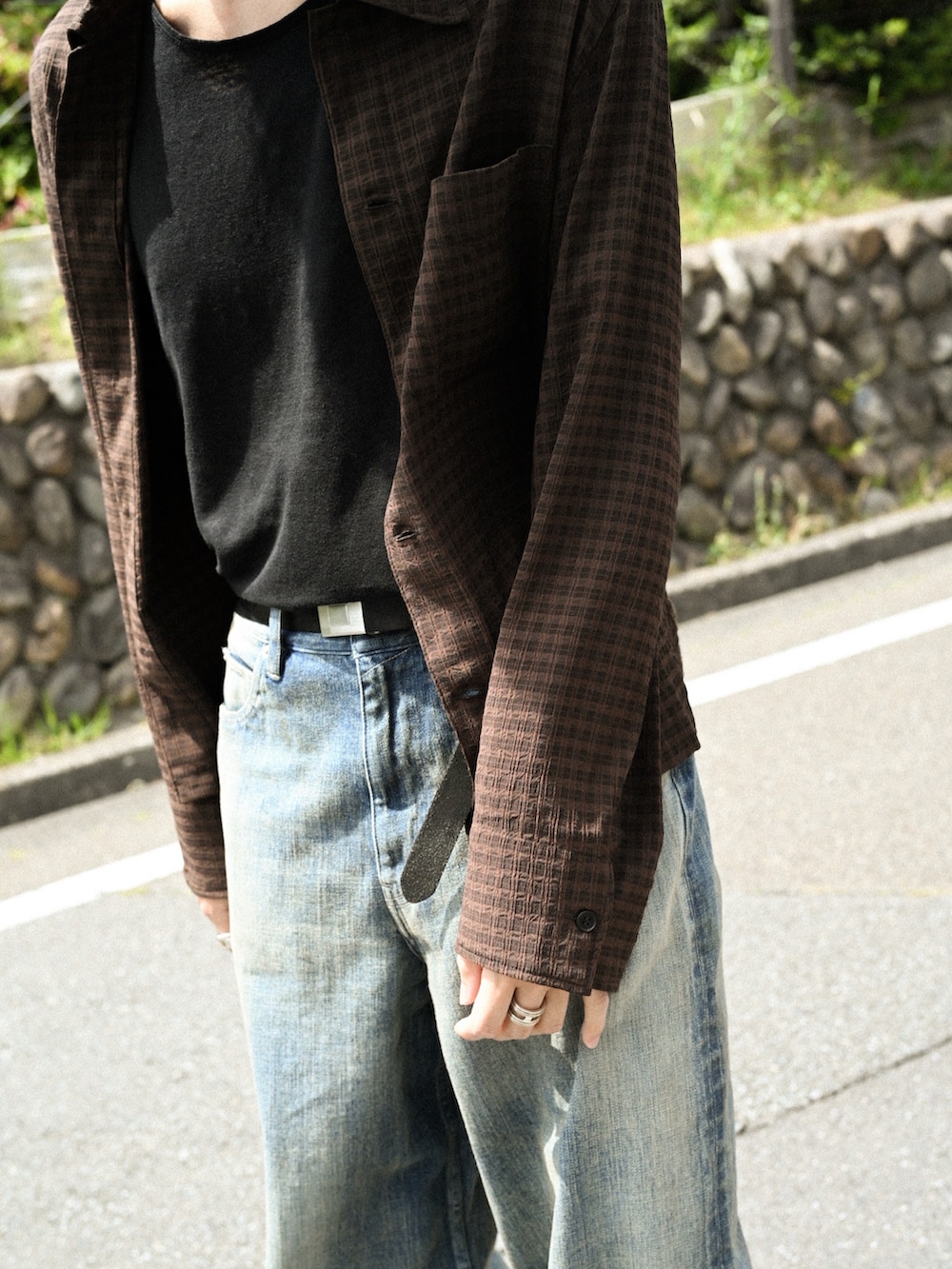 ブラック系のブーツ、ブラウン系のシャツ/ブラウス、ブルー系のデニムパンツを着用したメンズの春コーディネートの3枚目の写真