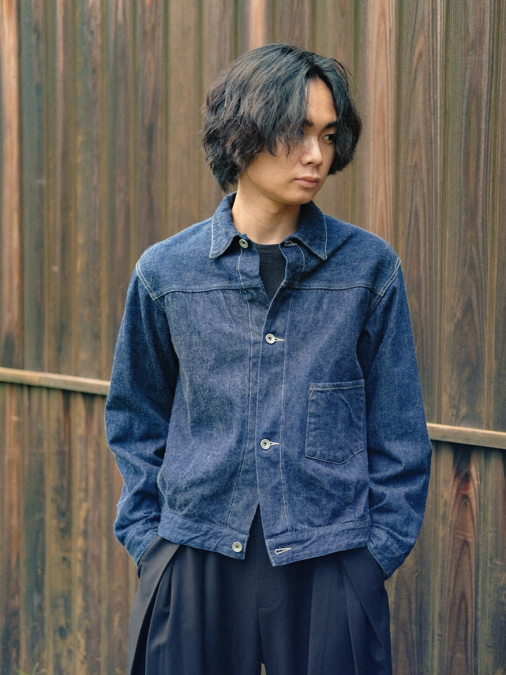 ブラック系のスラックス、ブラック系のTシャツ/カットソー、ブラック系のスニーカーを着用したメンズの秋コーディネートの2枚目の写真