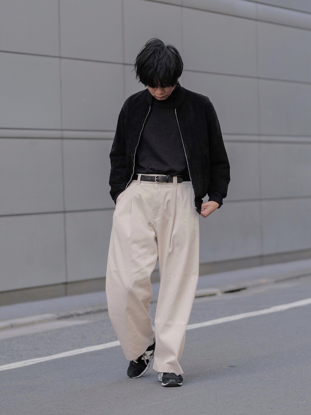 ブラック系のブルゾン、ホワイト系のその他パンツ、ブラック系のスニーカーを着用したメンズの春コーディネートの2枚目の写真