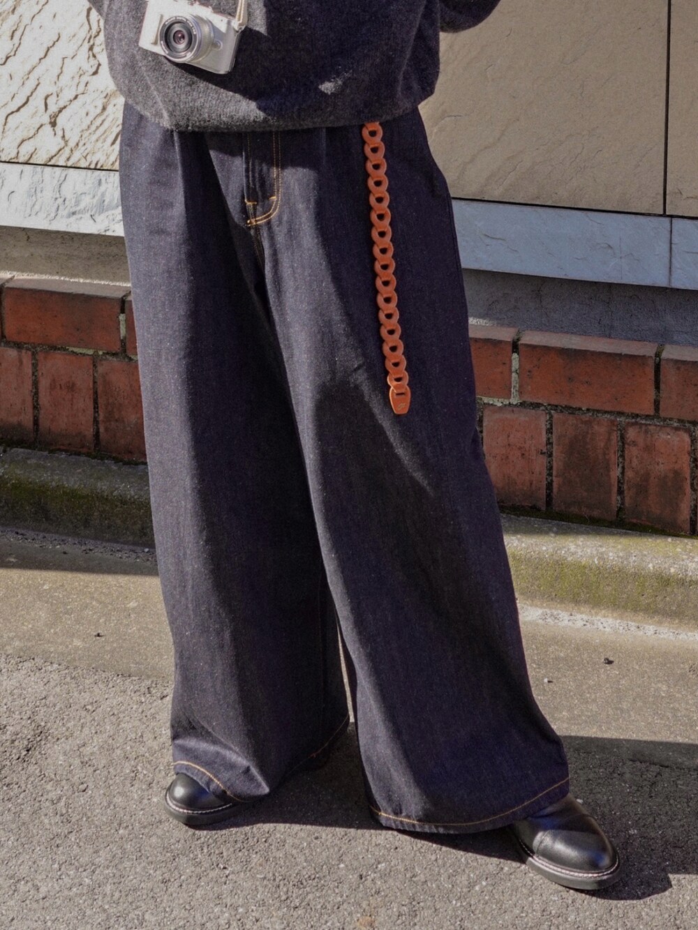 ブルー系のデニムパンツ、ブラック系のドレスシューズ、ブラック系のニット/セーターを着用したメンズの冬コーディネートの2枚目の写真