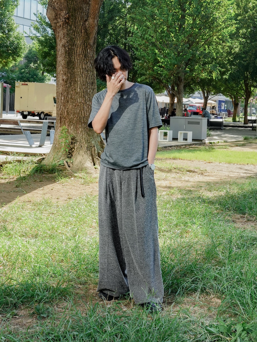 グレー系のTシャツ/カットソー、グレー系のスラックス、ブラック系のスニーカーを着用したメンズの秋コーディネートの2枚目の写真