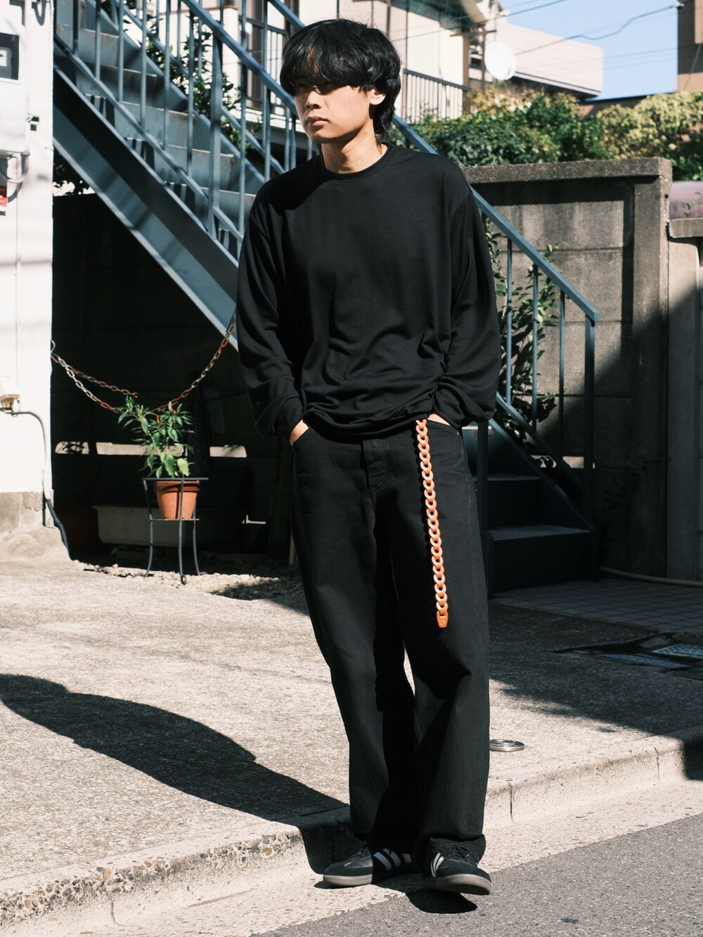 ブラック系のTシャツ/カットソー、ブラック系のデニムパンツ、ブラック系のスニーカーを着用したメンズの秋コーディネートの3枚目の写真