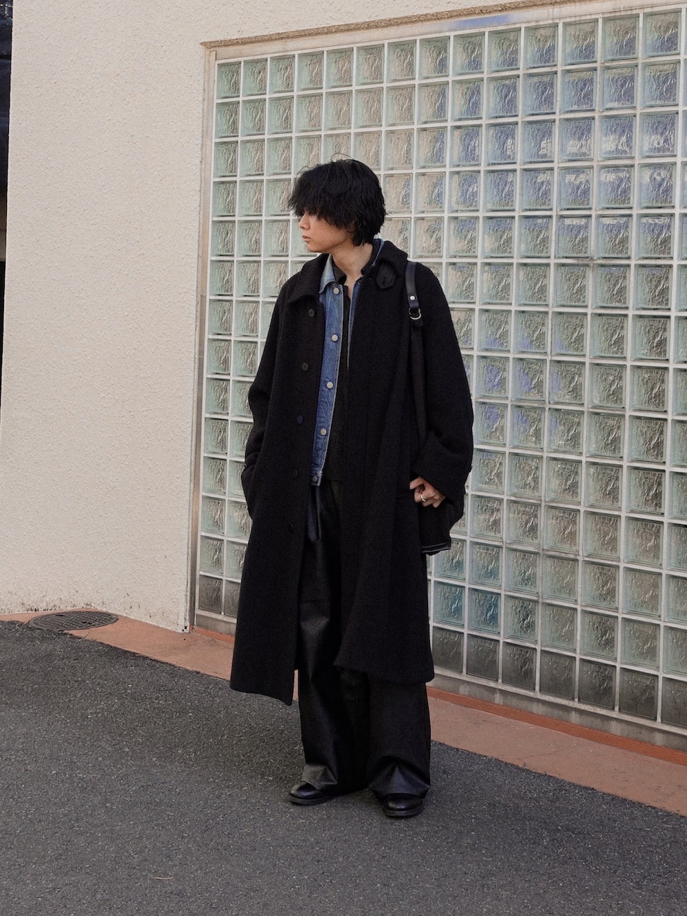 ブラック系のスラックス、ブラック系のブーツ、ブラック系のカーディガン/ボレロを着用したメンズの冬コーディネートの3枚目の写真