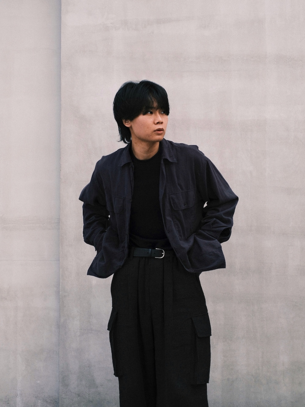 ブラック系のTシャツ/カットソー、ブルー系のシャツ/ブラウス、ブラウン系のカーゴパンツを着用したメンズの秋コーディネートの2枚目の写真