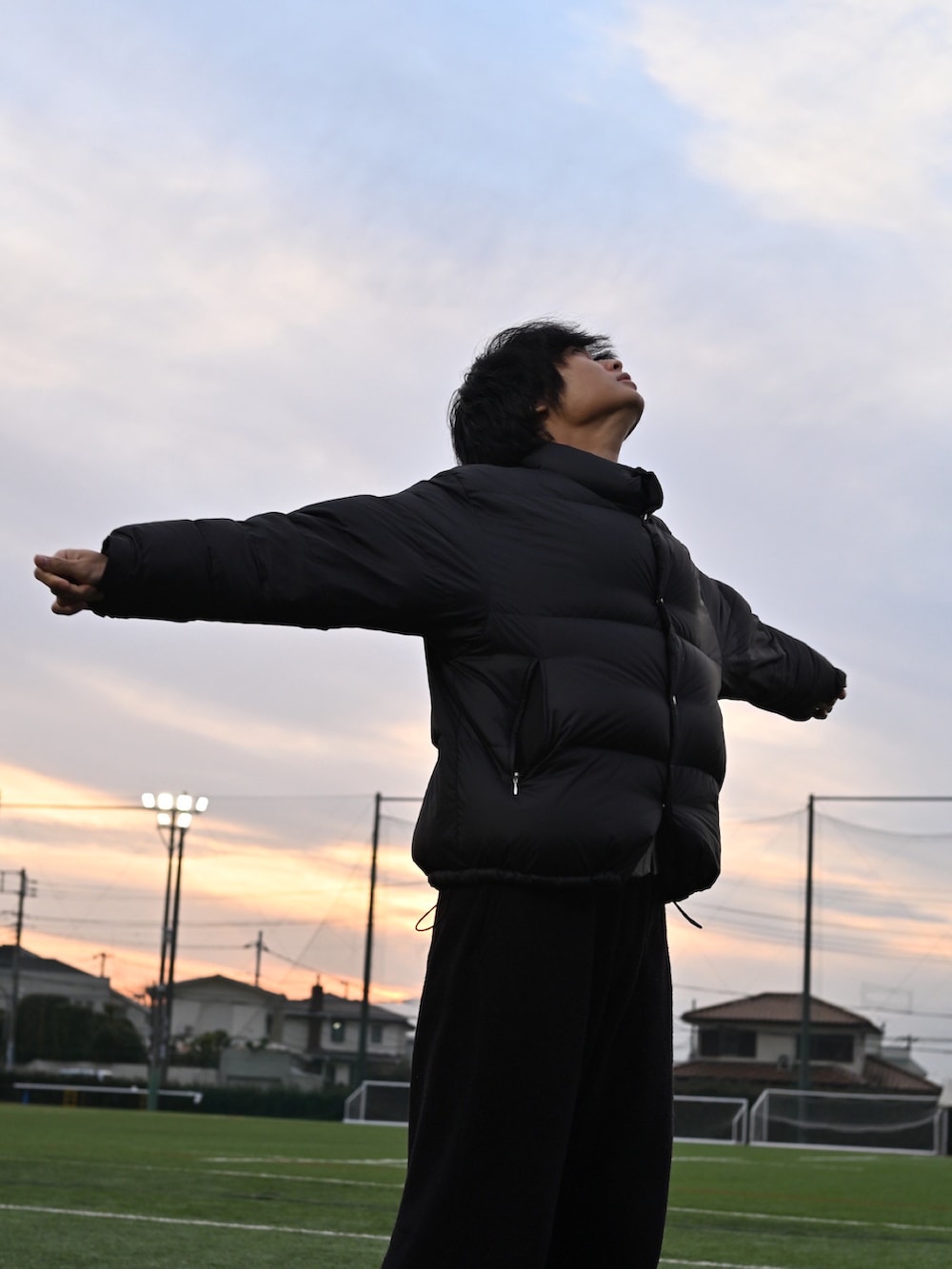 ブラック系のスニーカー、ブラック系のニット/セーター、ブラック系のダウンジャケット/コートを着用したメンズの冬コーディネートの3枚目の写真