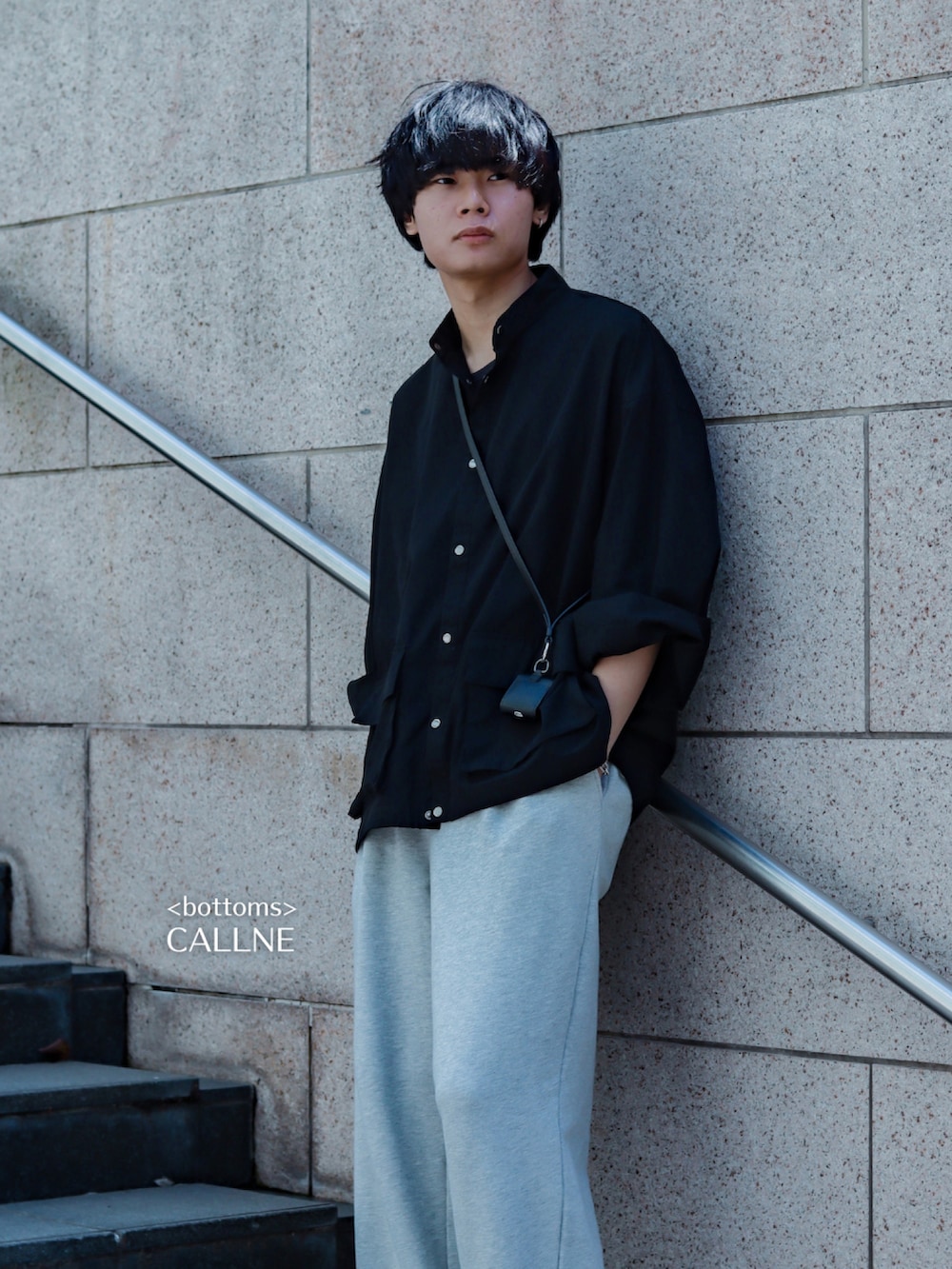 ブラック系のミリタリージャケット、グレー系のスウェットパンツ、ホワイト系のスニーカーを着用したメンズの春コーディネートの2枚目の写真