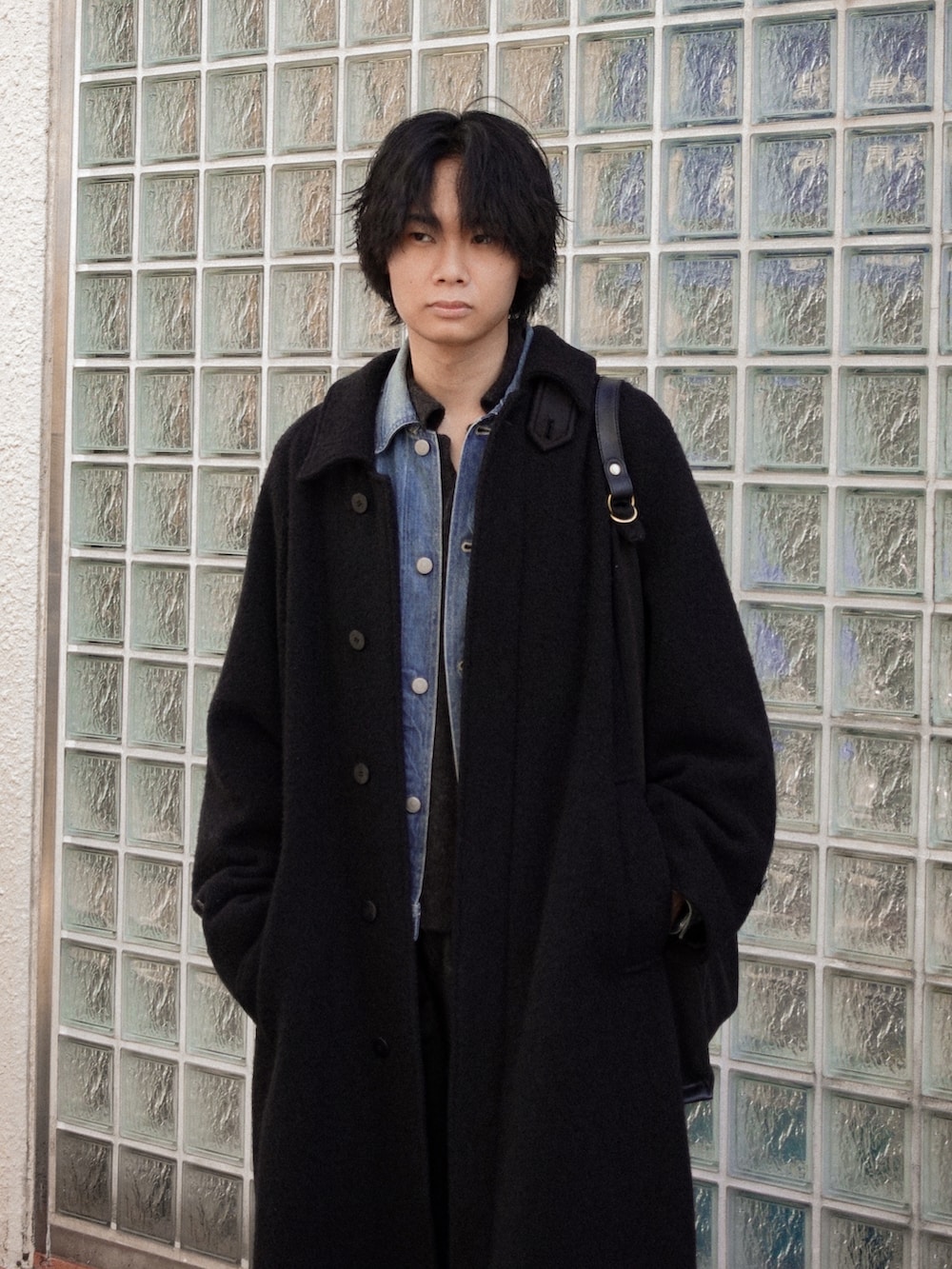 ブラック系のスラックス、ブラック系のブーツ、ブラック系のカーディガン/ボレロを着用したメンズの冬コーディネートの2枚目の写真