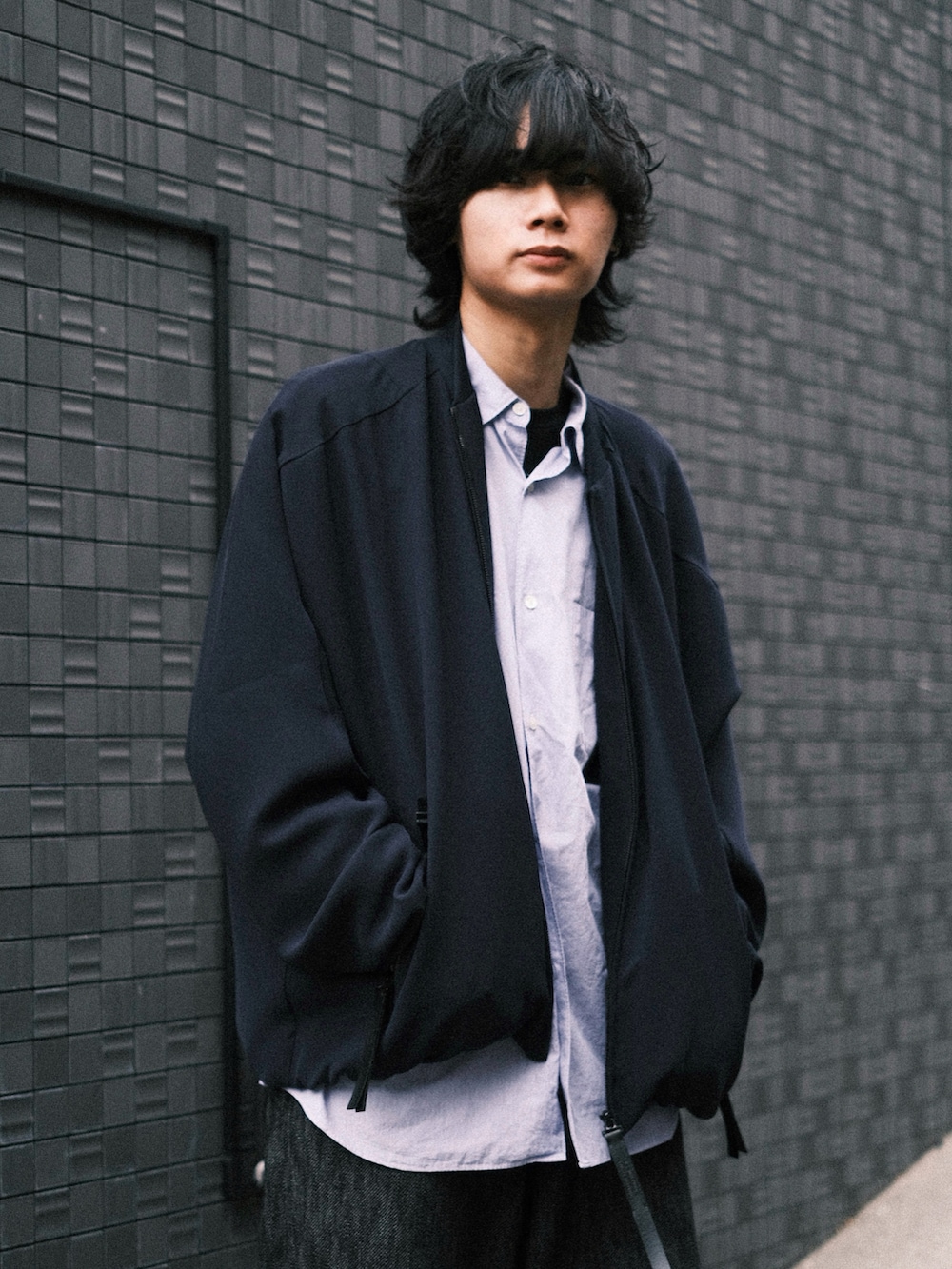 ブルー系のブルゾン、ブルー系のシャツ/ブラウス、ブラック系のTシャツ/カットソーを着用したメンズの春コーディネートの2枚目の写真