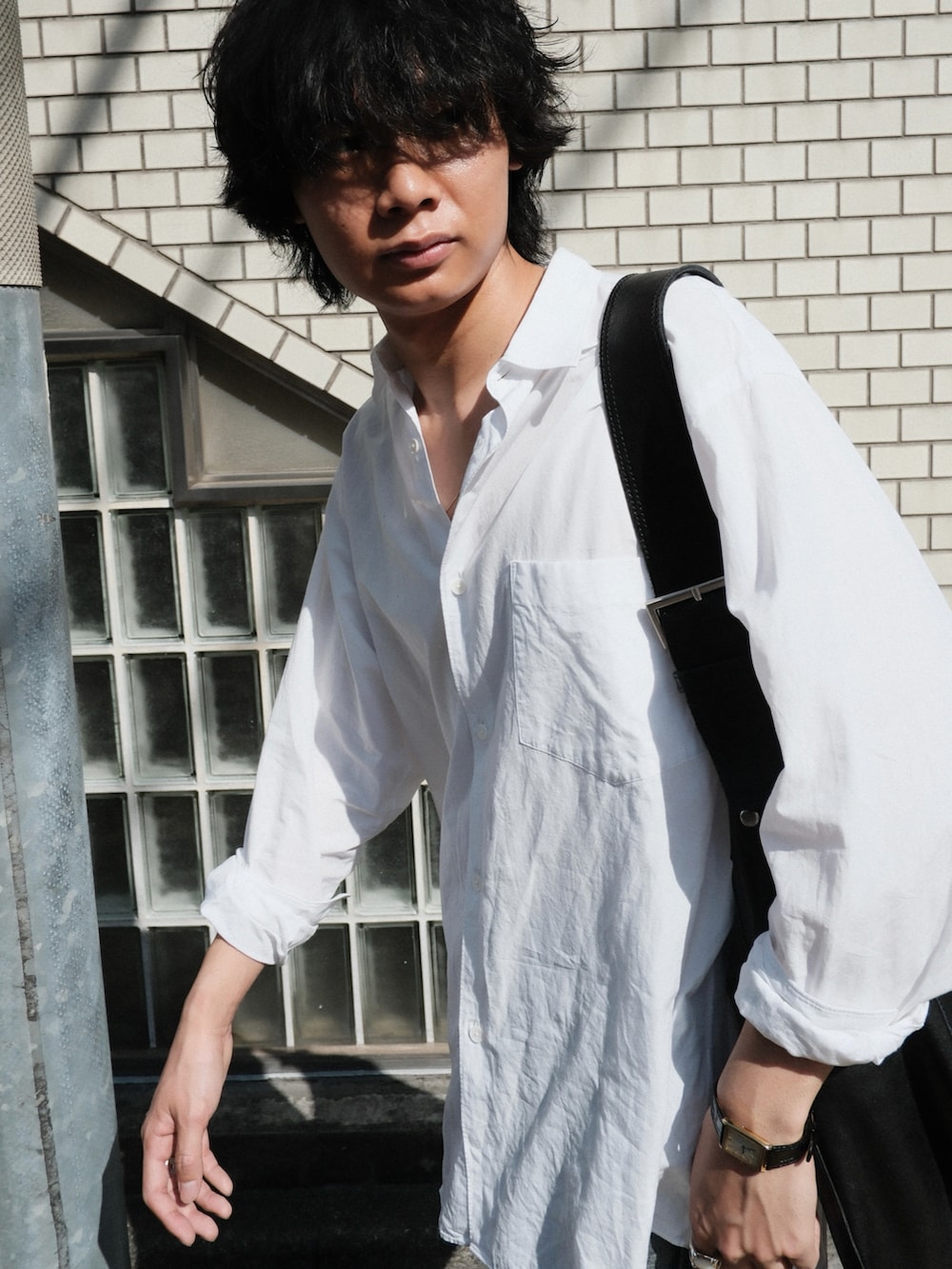 ブラック系のブーツ、ブルー系のデニムパンツ、ホワイト系のシャツ/ブラウスを着用したメンズの春コーディネートの3枚目の写真