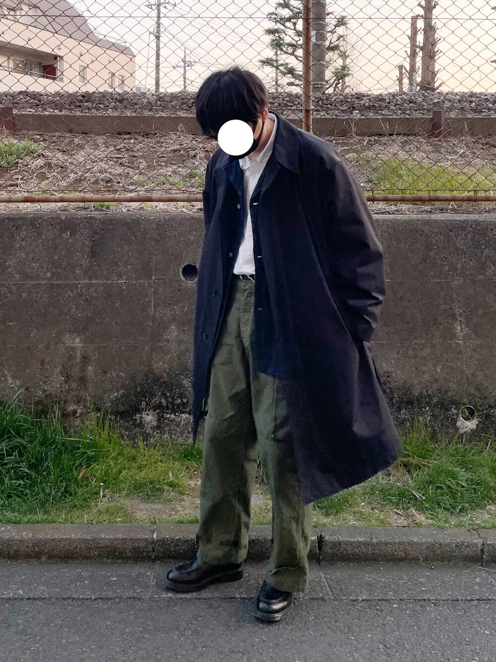 グリーン系のカーゴパンツ、ブラック系のステンカラーコート、ブルー系のデニムジャケットを着用したメンズの春コーディネートの4枚目の写真