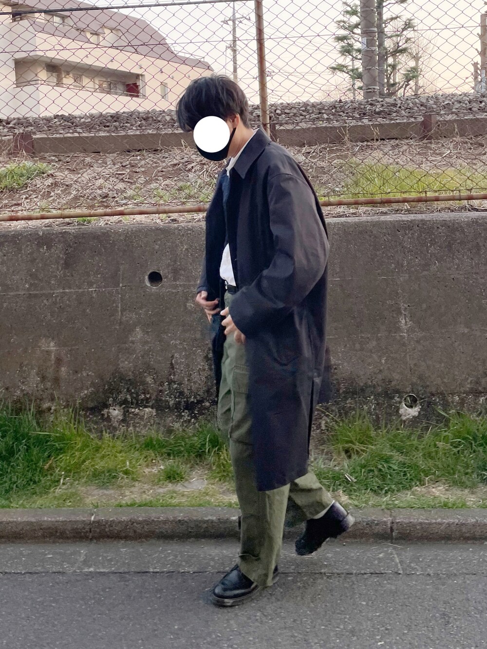 グリーン系のカーゴパンツ、ブラック系のステンカラーコート、ブルー系のデニムジャケットを着用したメンズの春コーディネートの3枚目の写真