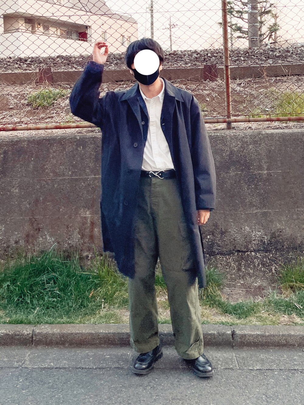 グリーン系のカーゴパンツ、ブラック系のステンカラーコート、ブルー系のデニムジャケットを着用したメンズの春コーディネートの2枚目の写真