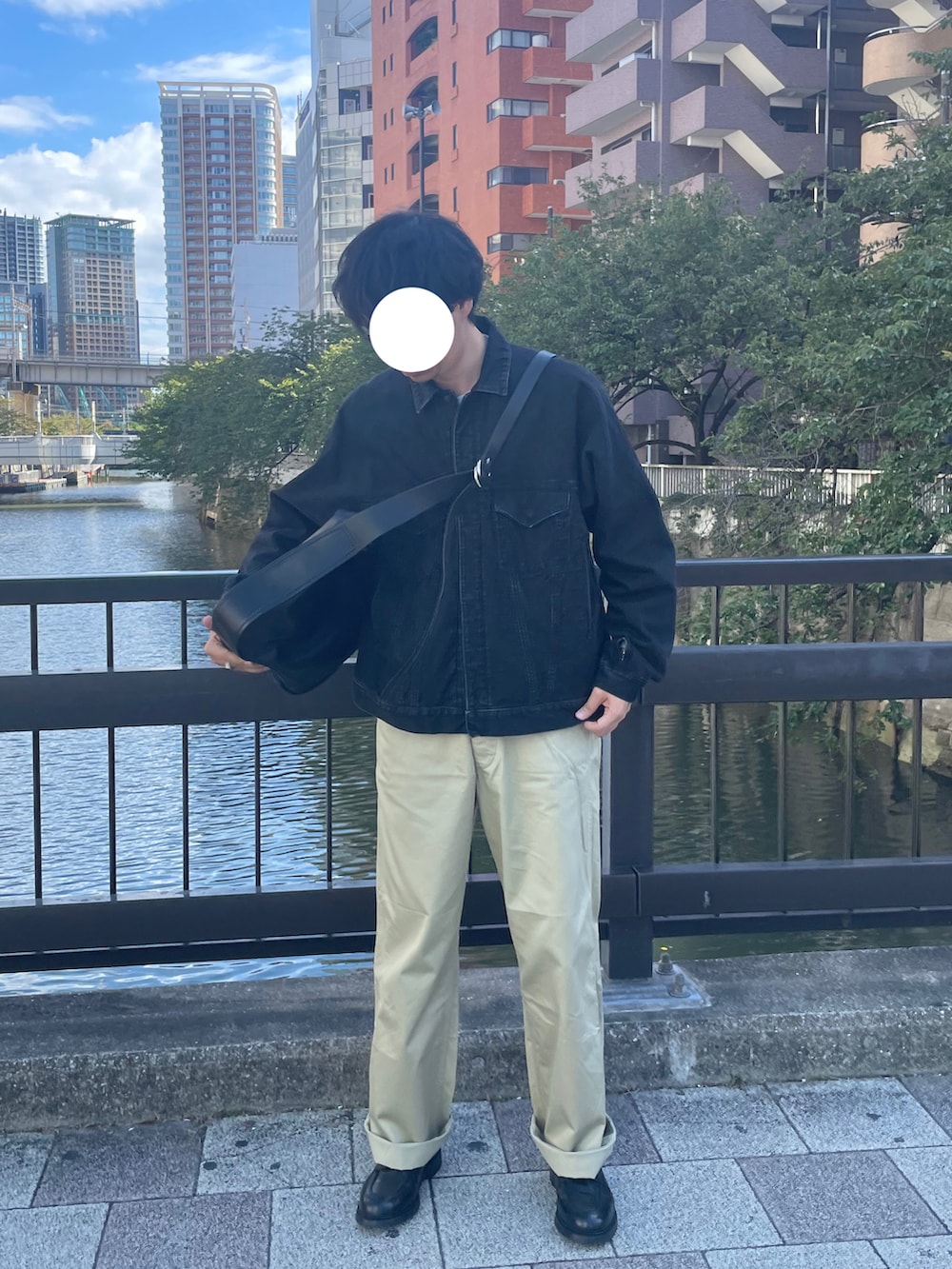 ベージュ系のチノパンツ、ブラック系のドレスシューズ、ブラック系のショルダーバッグを着用したメンズの秋コーディネートの2枚目の写真