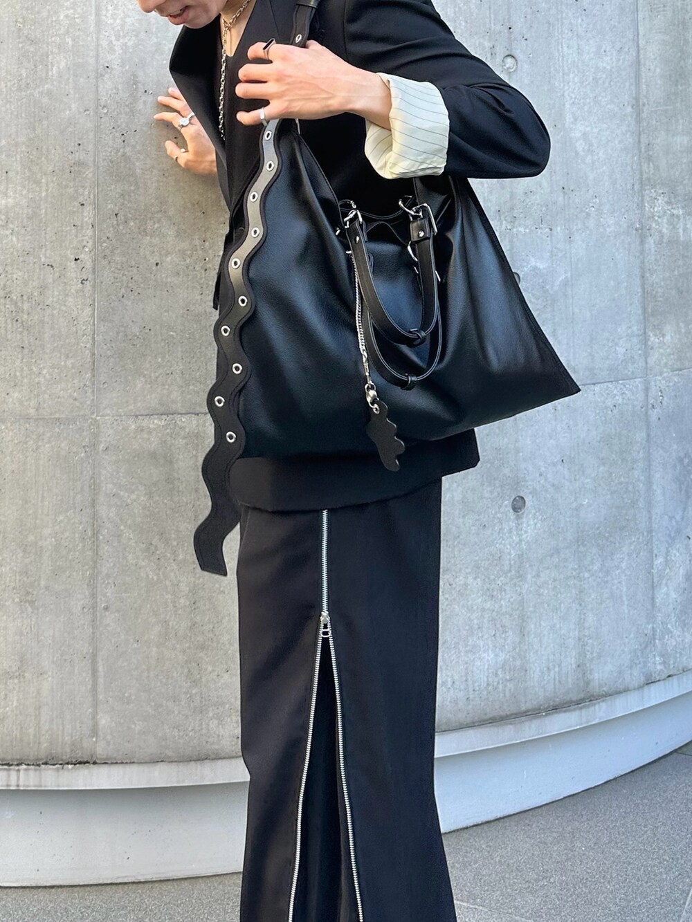 ブラック系のテーラードジャケット、ブラック系のスラックス、ホワイト系のブーツを着用したメンズの冬コーディネートの3枚目の写真