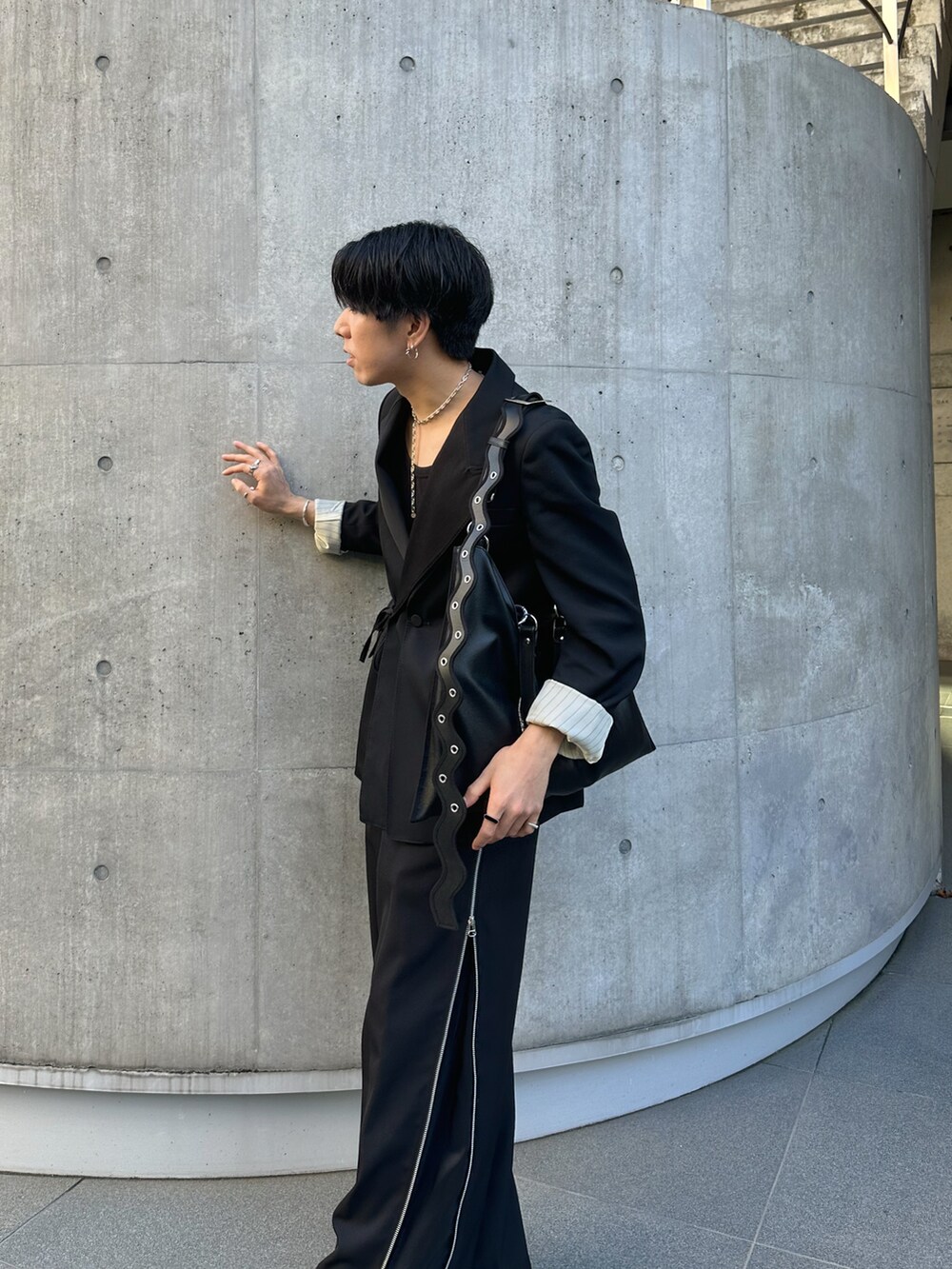 ブラック系のテーラードジャケット、ブラック系のスラックス、ホワイト系のブーツを着用したメンズの冬コーディネートの2枚目の写真