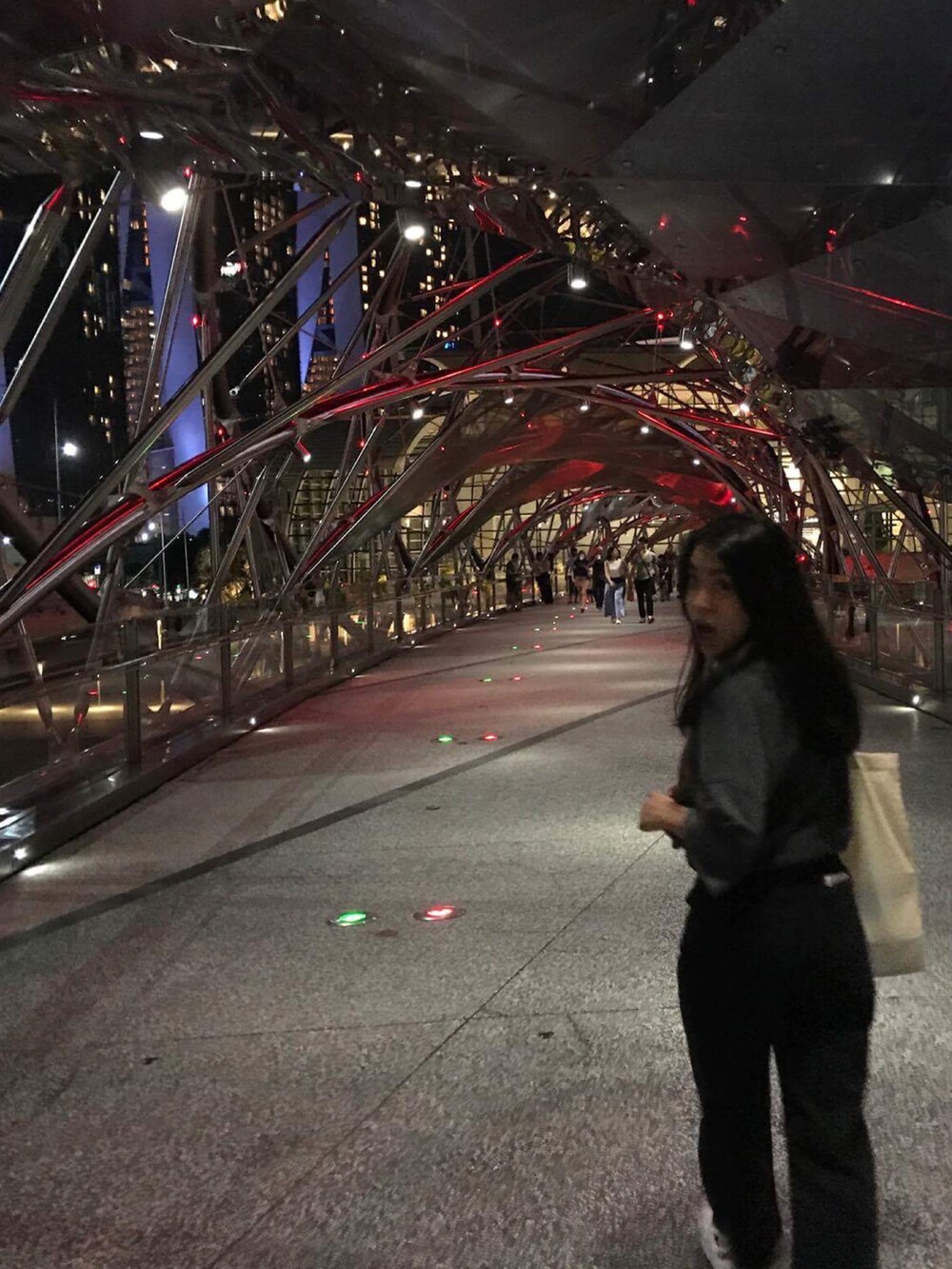 グレー系のTシャツ/カットソー、グレー系のデニムパンツ、ホワイト系のスニーカーを着用したレディースの秋コーディネートの2枚目の写真