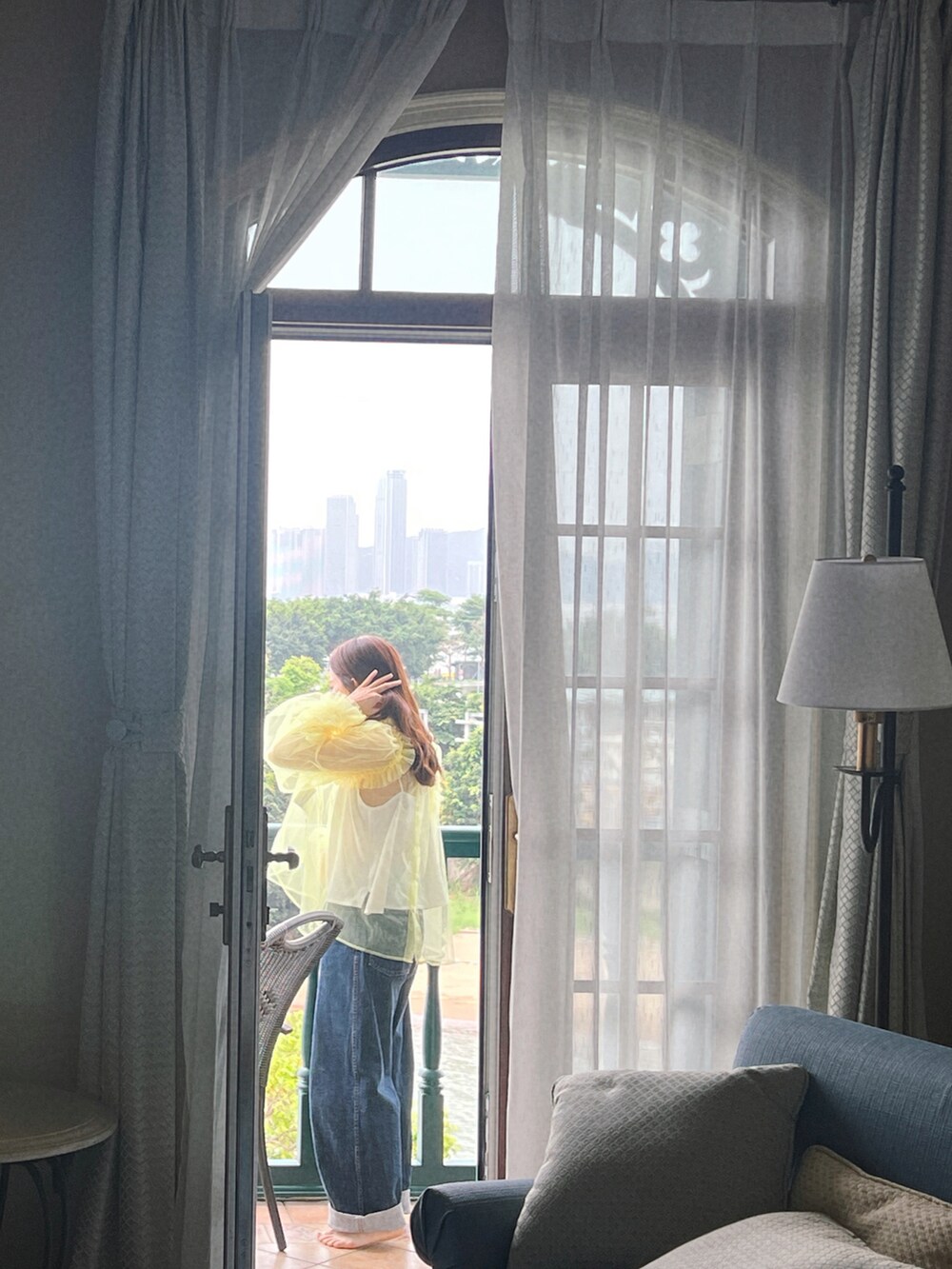 イエロー系のその他トップス、ホワイト系のキャミソール、ブルー系のデニムパンツを着用したレディースの春コーディネートの2枚目の写真