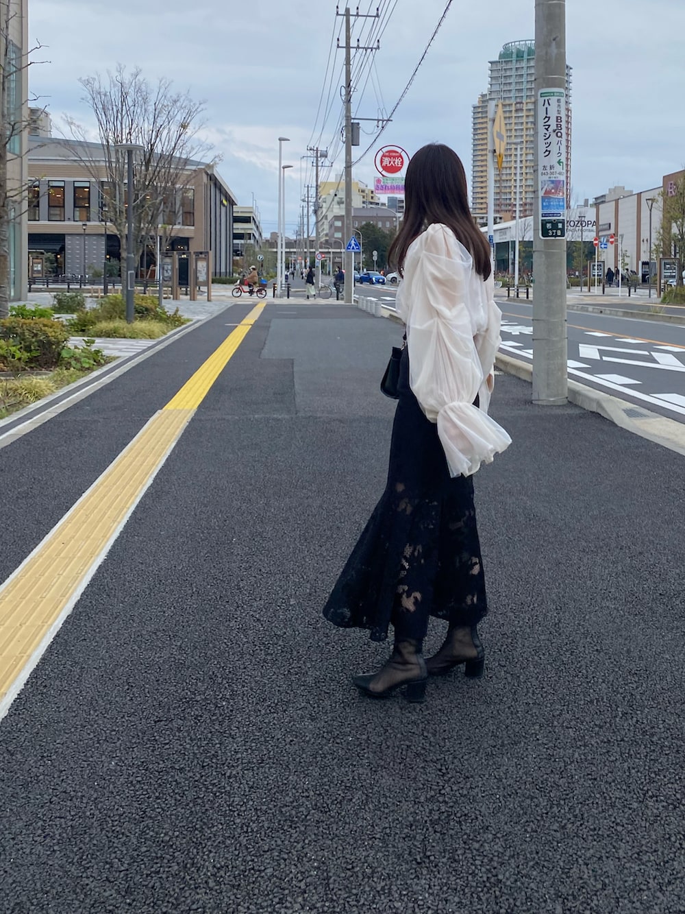 ホワイト系のシャツ/ブラウス、ブラック系のスカートを着用したレディースの春コーディネートの2枚目の写真