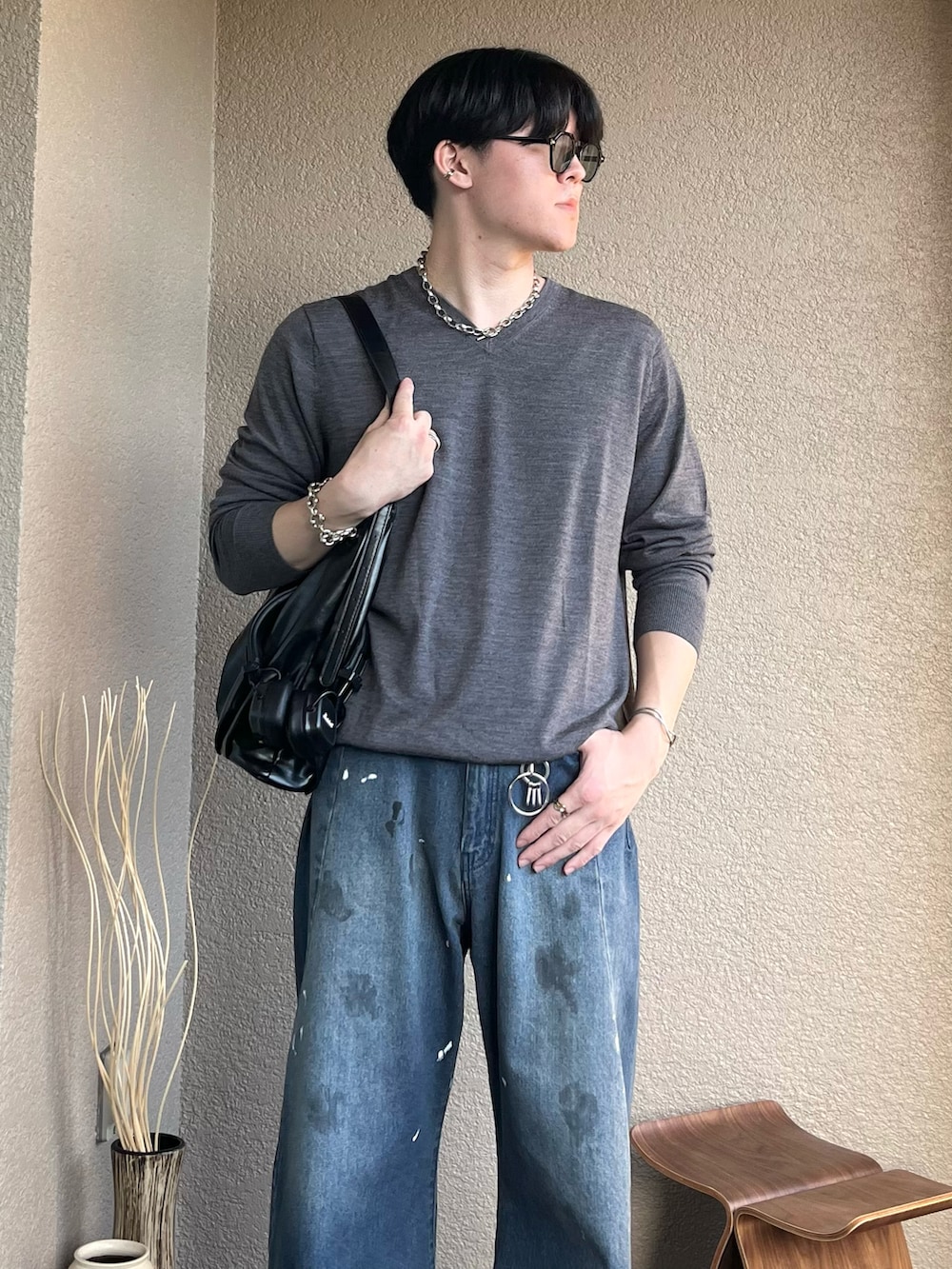 ブラック系のショルダーバッグ、ブルー系のデニムパンツ、ブラック系のドレスシューズを着用したメンズの秋コーディネートの2枚目の写真