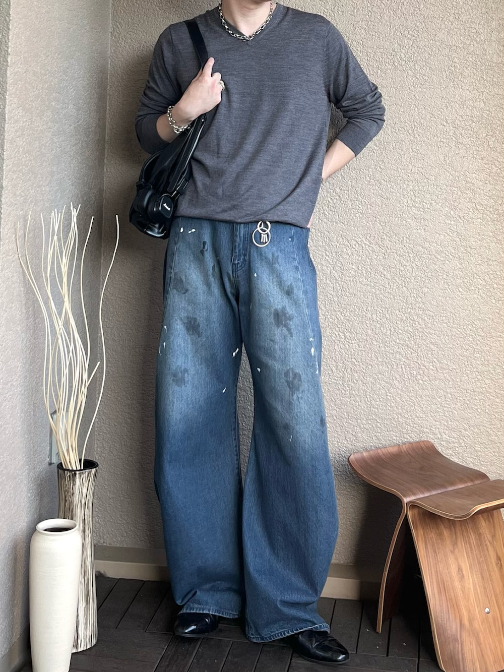 ブラック系のショルダーバッグ、ブルー系のデニムパンツ、ブラック系のドレスシューズを着用したメンズの秋コーディネートの3枚目の写真