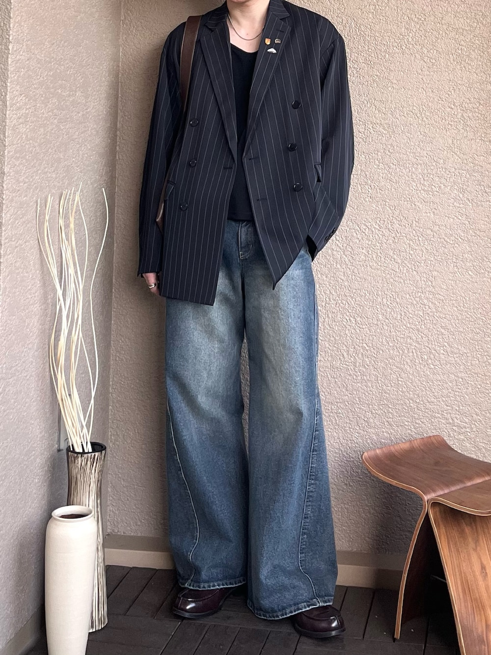 レッド系のローファー、ブラウン系のショルダーバッグ、ブラック系のタンクトップを着用したメンズの秋コーディネートの3枚目の写真