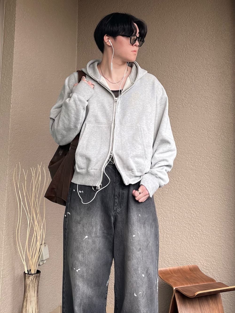 ブラウン系のショルダーバッグ、グレー系のパーカー、ブラック系のデニムパンツを着用したメンズの秋コーディネートの2枚目の写真