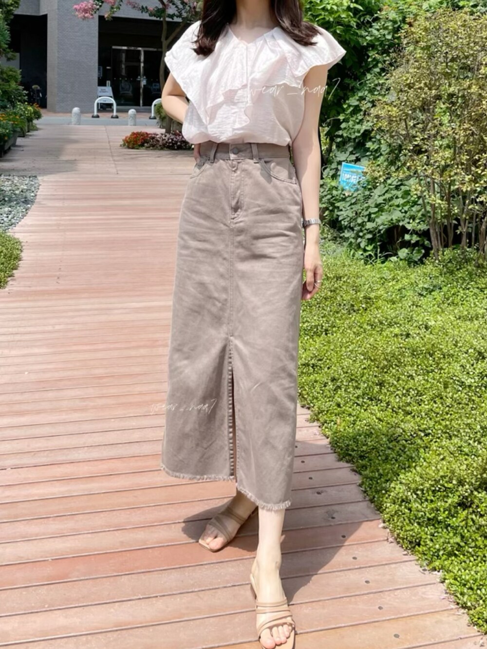 ピンク系のシャツ/ブラウス、イエロー系のサンダル、ブラウン系のデニムスカートを着用したレディースの夏コーディネートの2枚目の写真