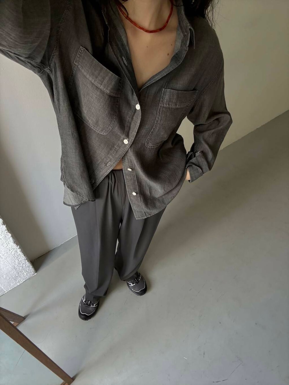 グレー系のスニーカー、ブラック系のシャツ/ブラウス、レッド系のネックレスを着用したレディースの夏コーディネートの2枚目の写真