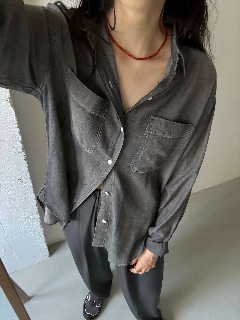 グレー系のスニーカー、ブラック系のシャツ/ブラウス、レッド系のネックレスを着用したレディースの夏コーディネートの3枚目の写真