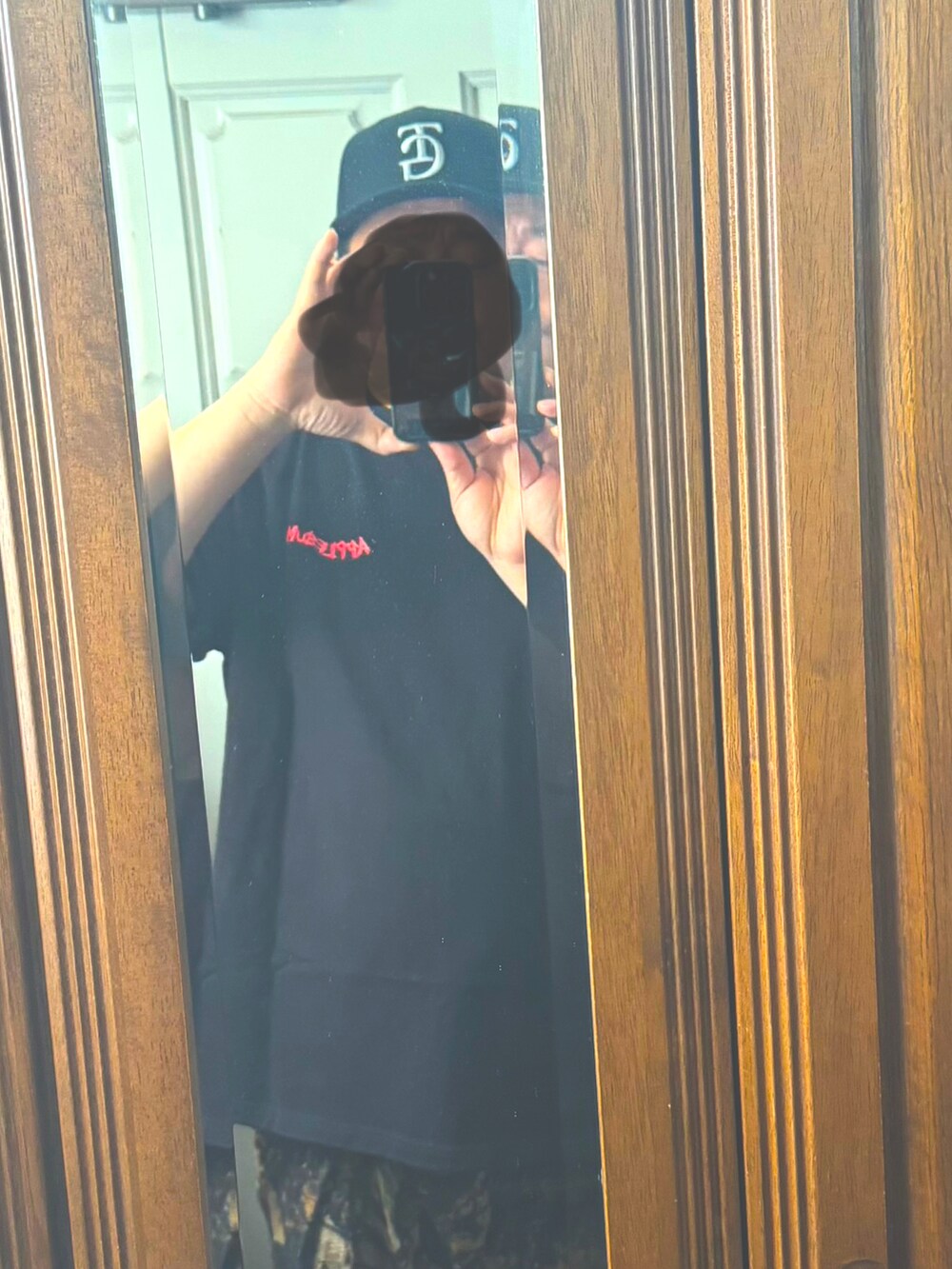 ブラック系のTシャツ/カットソー、ブラウン系のチノパンツ、ブラック系のスニーカーを着用したメンズの夏コーディネートの2枚目の写真