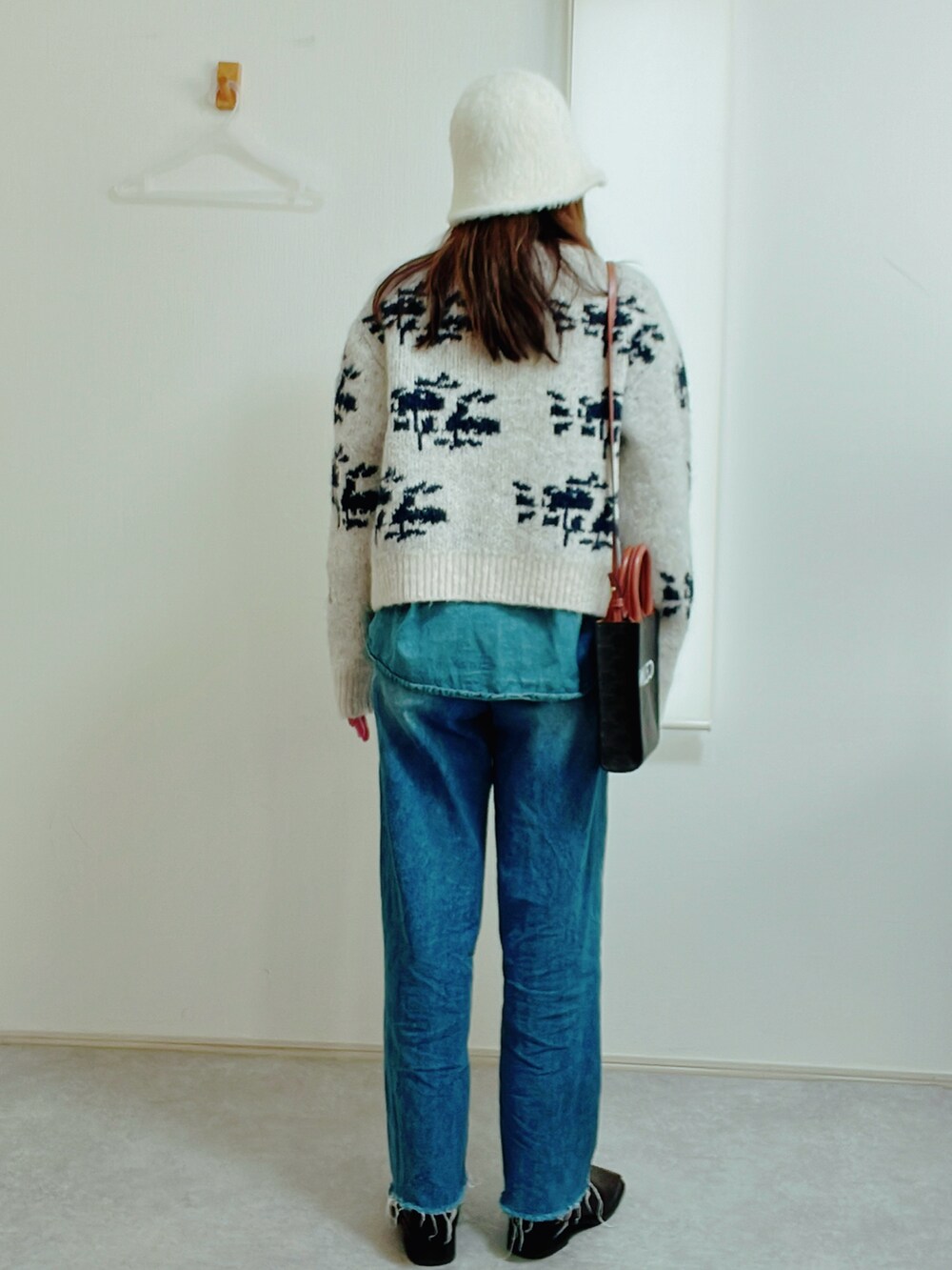 ホワイト系のカーディガン/ボレロ、ブルー系のデニムパンツ、ブラウン系のブーツを着用したレディースの冬コーディネートの3枚目の写真