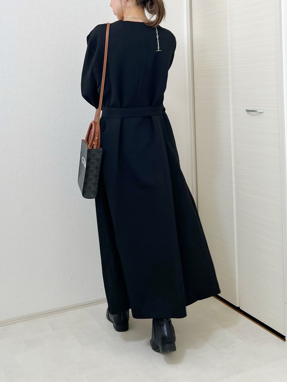 ブラック系のワンピース、ブラック系のブーツを着用したレディースの秋コーディネートの3枚目の写真