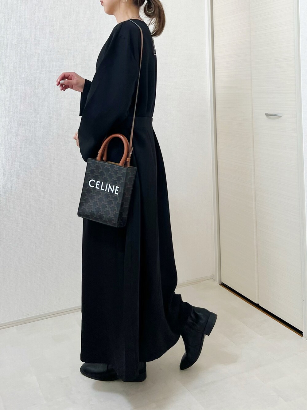 ブラック系のワンピース、ブラック系のブーツを着用したレディースの秋コーディネートの2枚目の写真