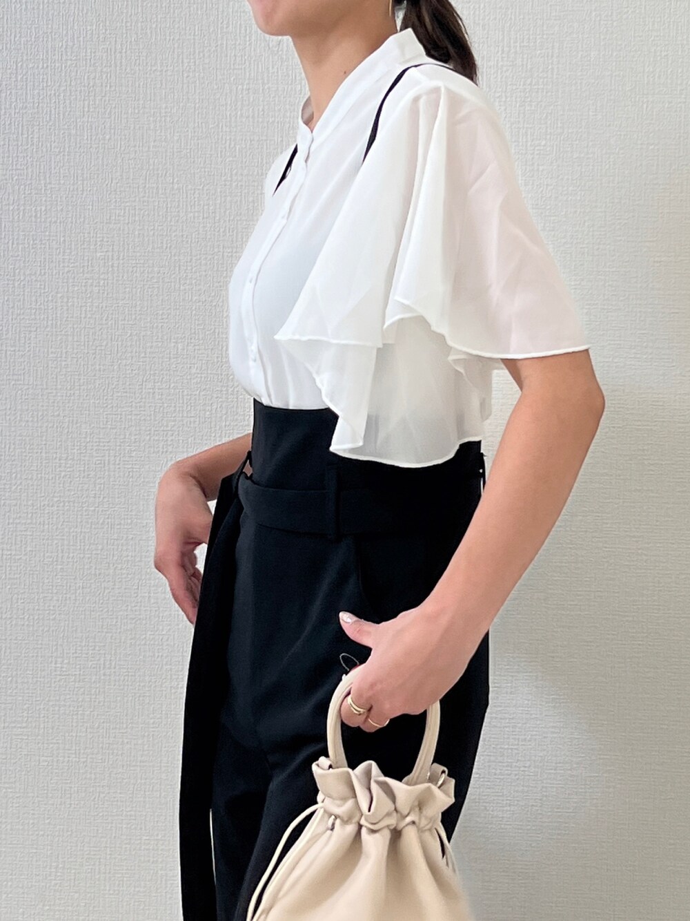 ベージュ系のショルダーバッグを着用したレディースの夏コーディネートの2枚目の写真