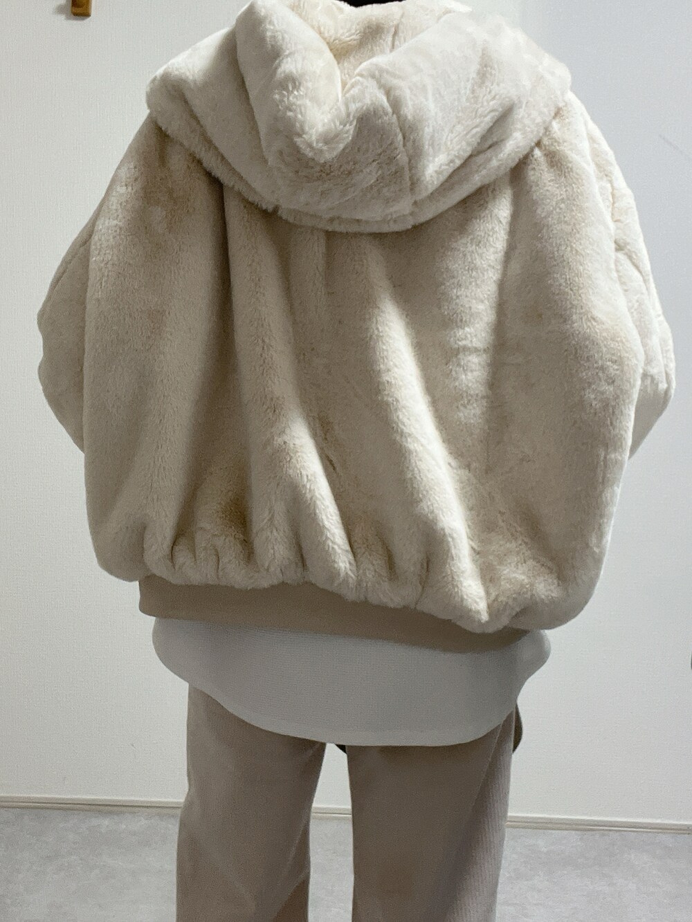 ベージュ系のブルゾン、ベージュ系のスニーカー、ホワイト系のパンツを着用したレディースの冬コーディネートの4枚目の写真