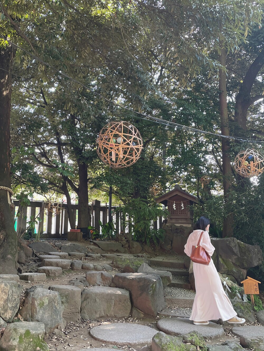 ブラウン系のバッグ、ピンク系のシャツ/ブラウス、ホワイト系のスカートを着用したレディースの夏コーディネートの2枚目の写真