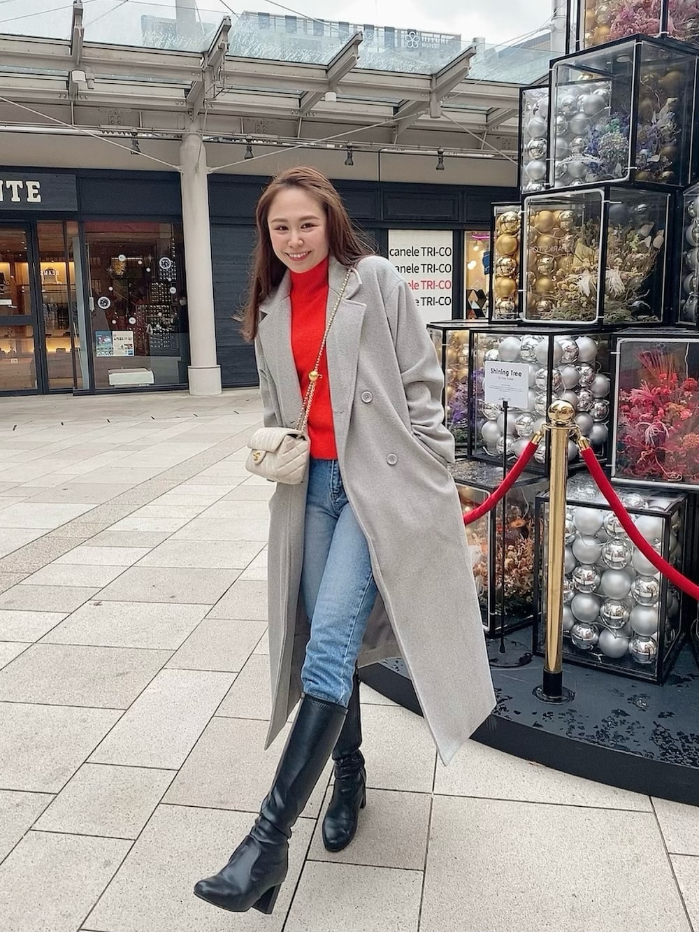 グレー系のチェスターコート、ベージュ系のショルダーバッグを着用したレディースの春コーディネートの3枚目の写真