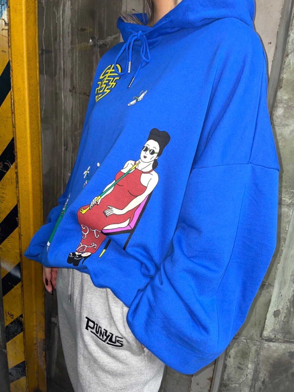 グレー系のスウェットパンツ、ブルー系のパーカーを着用したレディースの秋コーディネートの3枚目の写真