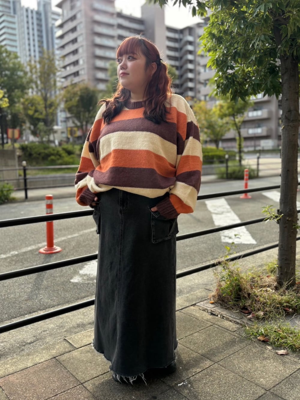 ブラック系のデニムスカート、ブラウン系のニット/セーターを着用したレディースの秋コーディネートの2枚目の写真