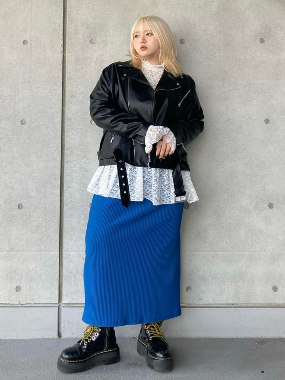 ブラック系のライダースジャケット、ホワイト系のTシャツ/カットソー、ブルー系のスカートを着用したレディースの秋コーディネートの3枚目の写真