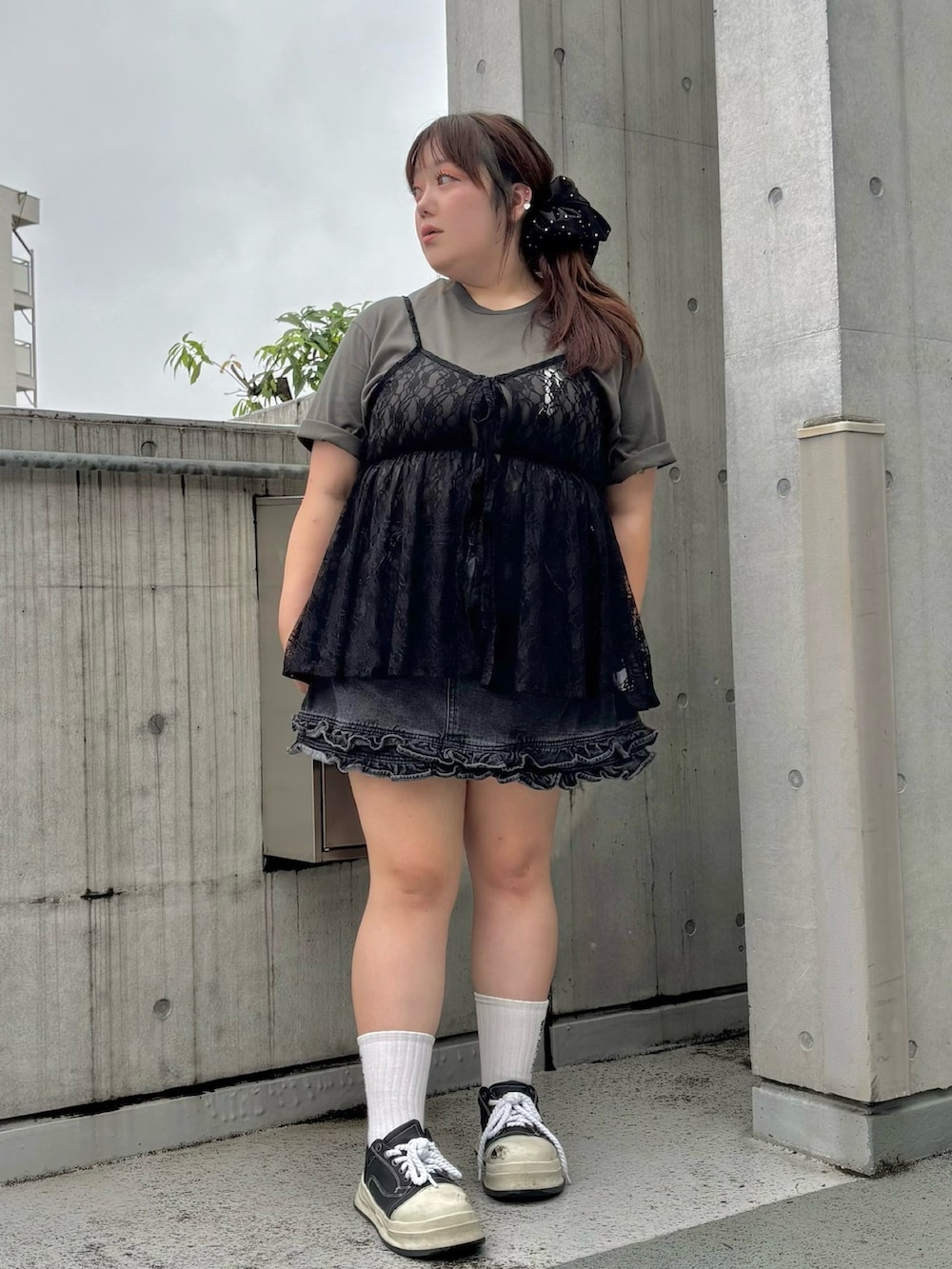 ブラック系のチュニック、ブラック系のデニムスカート、ブラック系のTシャツ/カットソーを着用したレディースの夏コーディネートの2枚目の写真