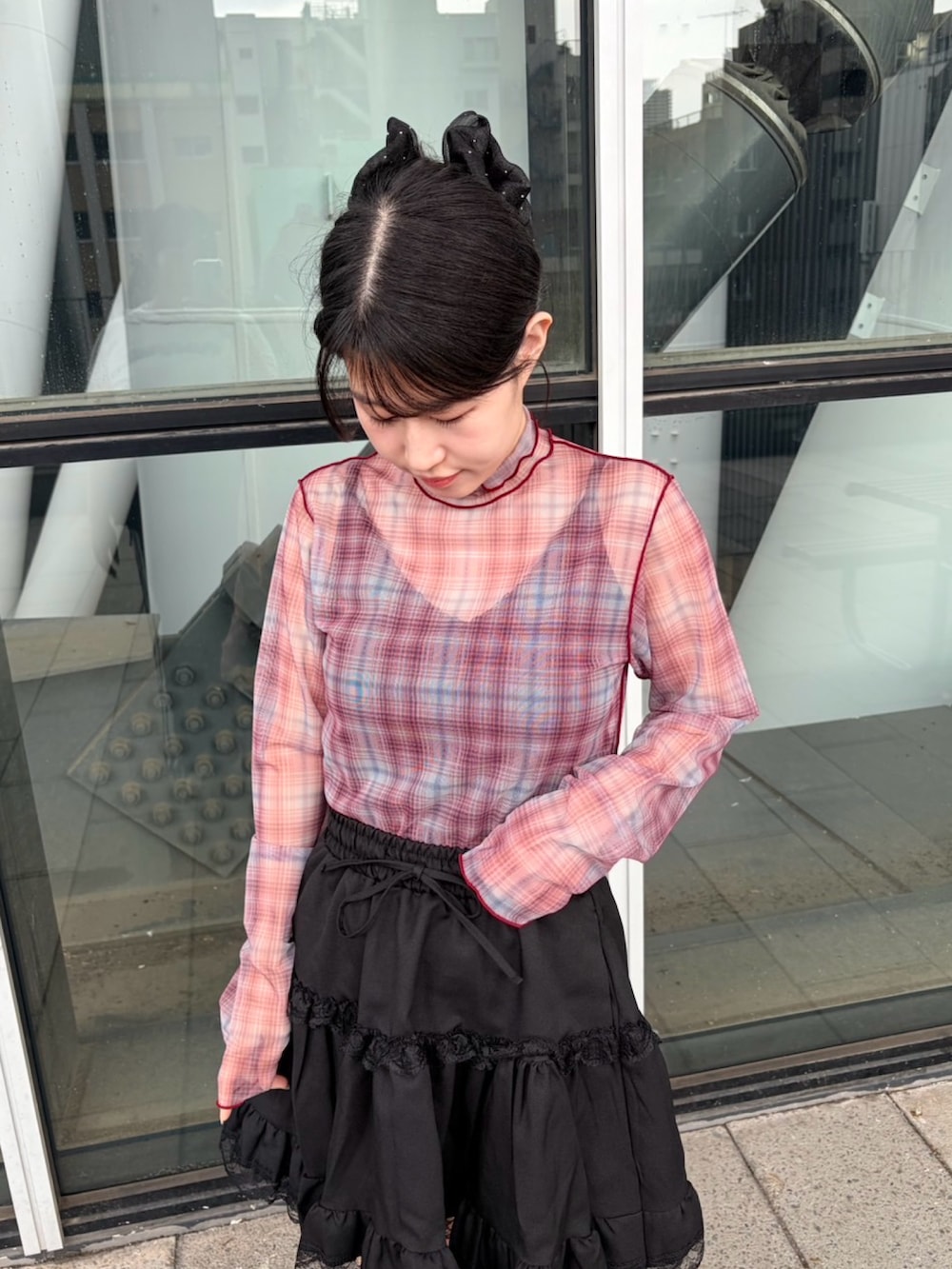 ブラック系のスカート、レッド系のTシャツ/カットソー、ブラック系のキャミソールを着用したレディースの秋コーディネートの5枚目の写真