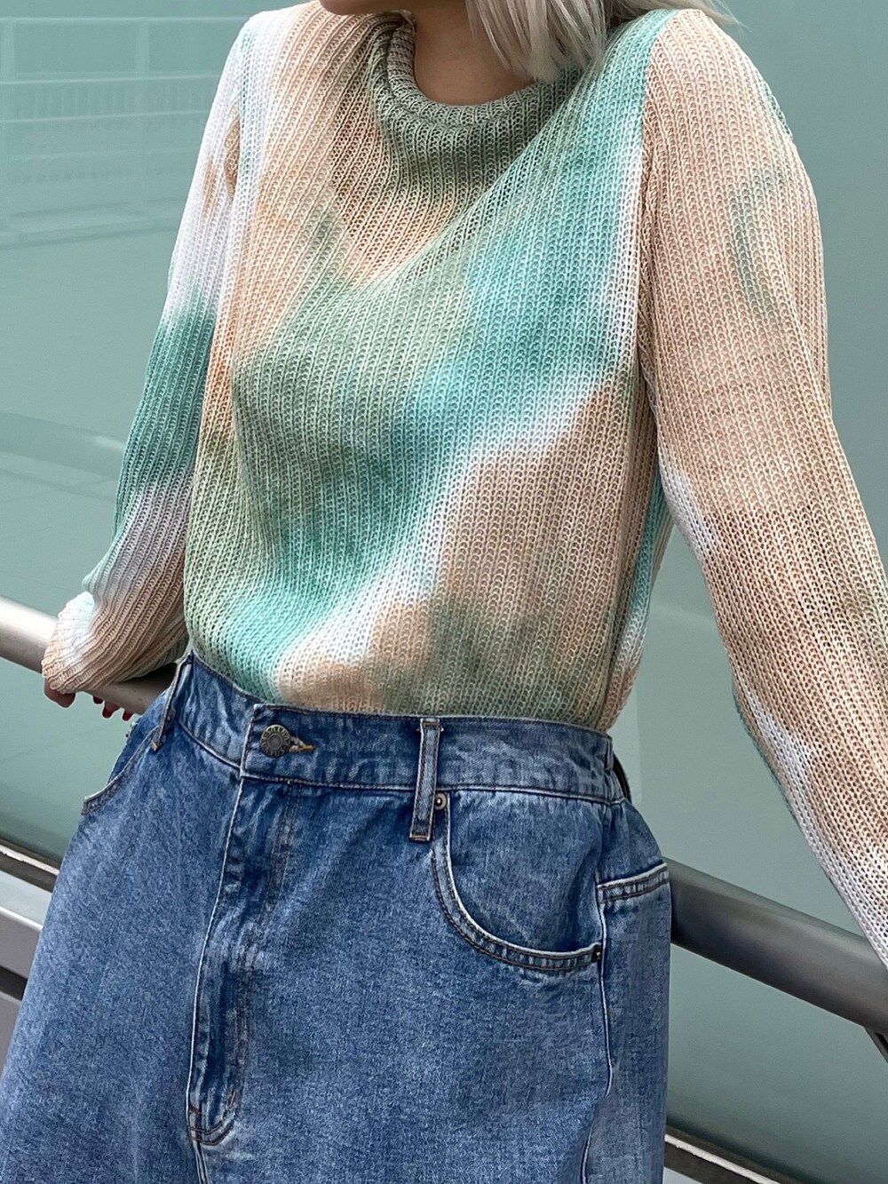 ブルー系のデニムパンツ、グリーン系のニット/セーターを着用したレディースの春コーディネートの3枚目の写真