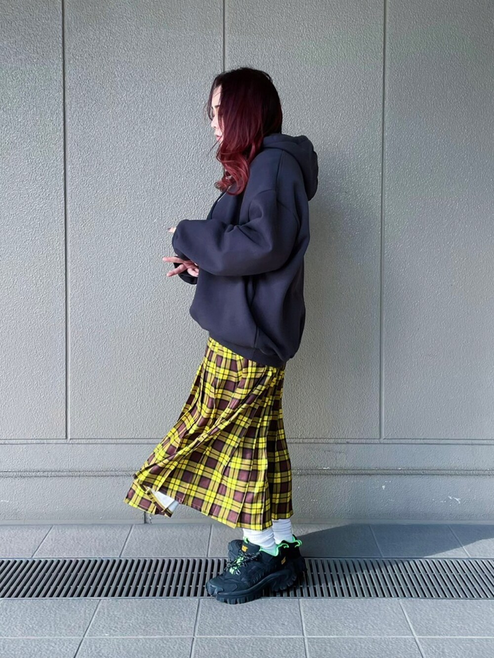ブラック系のパーカー、イエロー系のスカートを着用したレディースの冬コーディネートの2枚目の写真