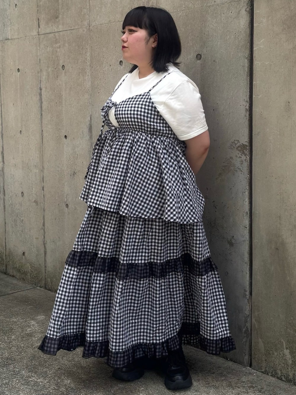 ブラック系のスカート、ブラック系のキャミソール、ホワイト系のTシャツ/カットソーを着用したレディースの春コーディネートの3枚目の写真