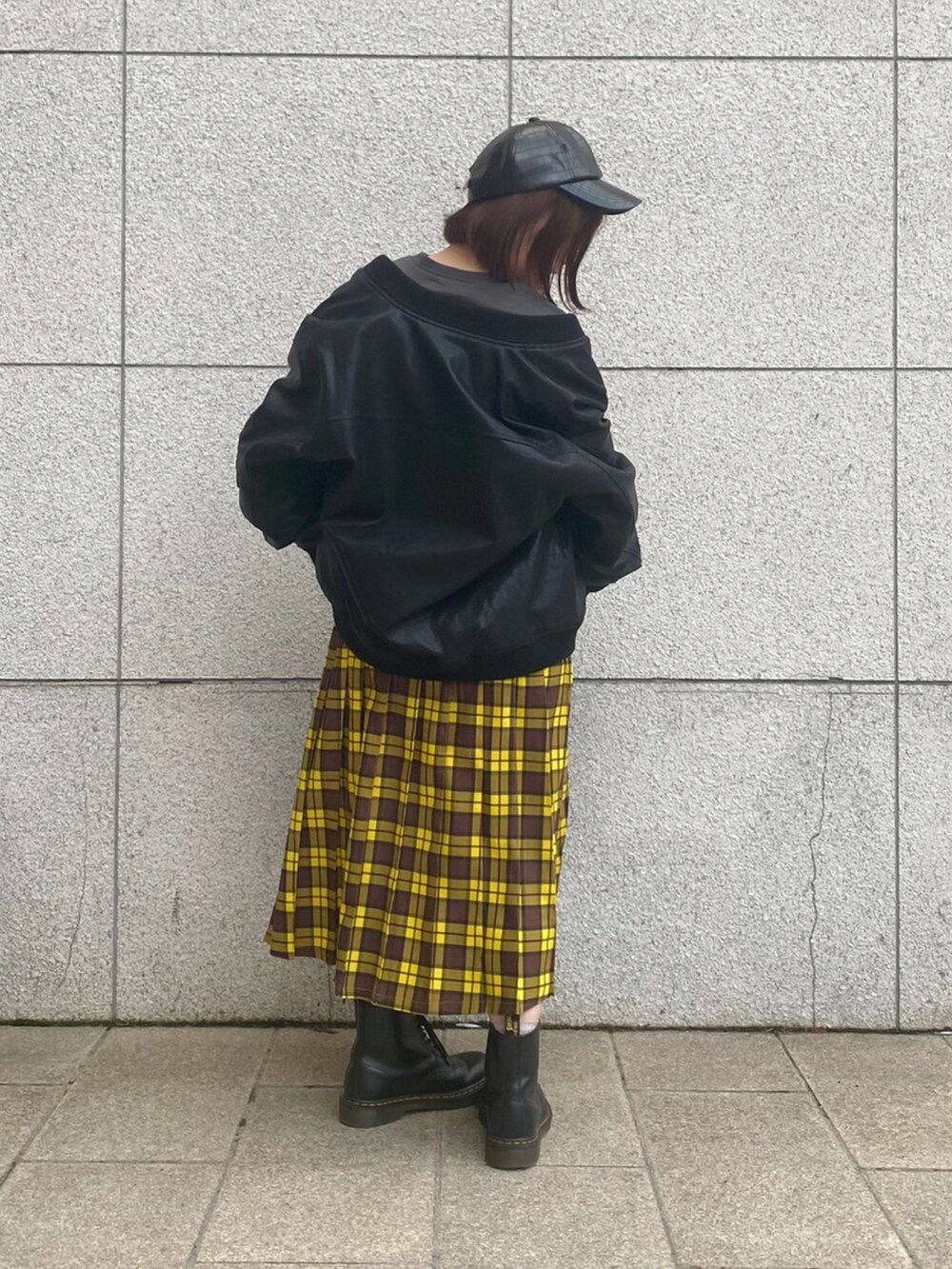 イエロー系のスカート、ブラック系のTシャツ/カットソー、ブラック系のMA-1を着用したレディースの冬コーディネートの2枚目の写真