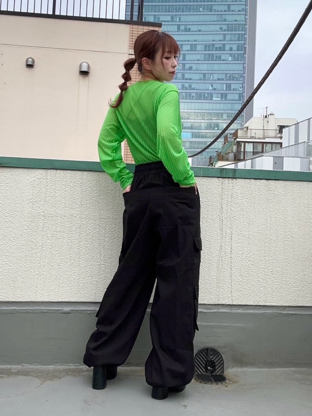 グリーン系のTシャツ/カットソー、ブラック系のカーゴパンツを着用したレディースの春コーディネートの3枚目の写真