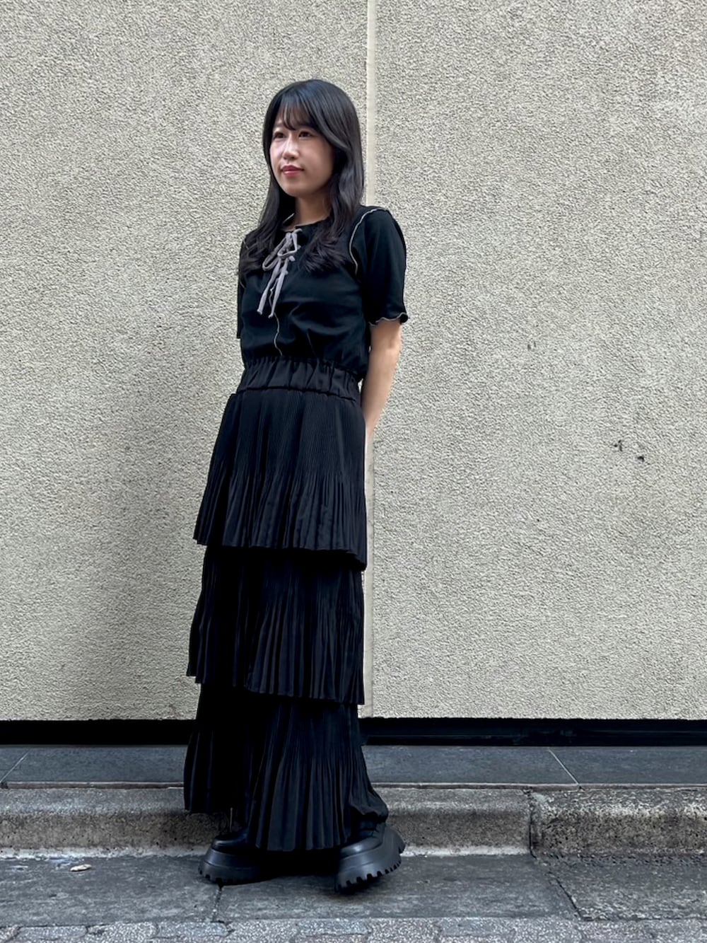 ブラック系のスカート、ブラック系のTシャツ/カットソーを着用したレディースの秋コーディネートの2枚目の写真